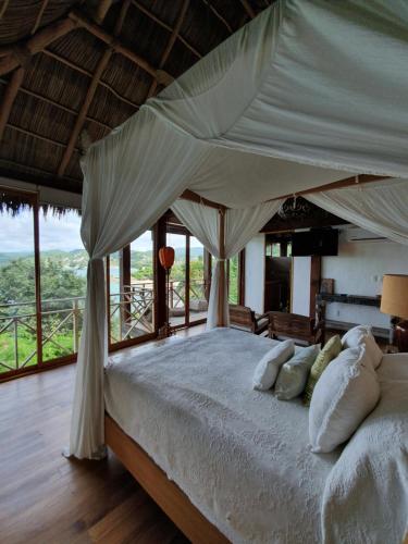 a bedroom with a large bed with a canopy at Hotel Boutique Siete Lunas in Sayulita
