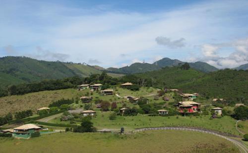 a village on a hill with mountains in the background at Maua Brasil Hotelaria in Visconde De Maua