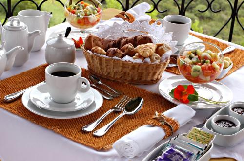 a table with a plate of food and a cup of coffee at Maua Brasil Hotelaria in Visconde De Maua