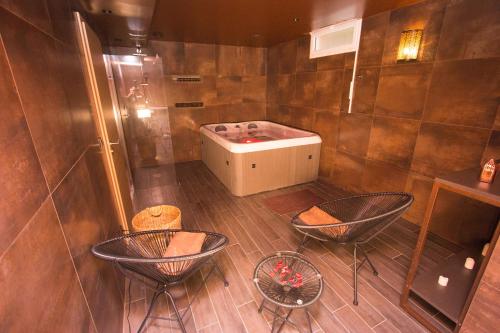 a bathroom with three chairs and a bath tub at Le Nautile in Hyères