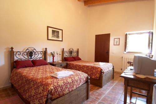 a hotel room with two beds and a television at Quinta Pero Vicente in Odeceixe
