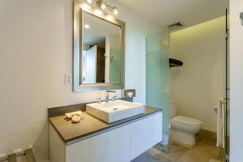 a bathroom with a sink and a mirror and a toilet at Oceana by ABNA in Playa del Carmen