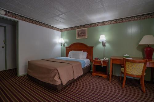 a hotel room with a bed and a desk and a bed sidx sidx at Mahoning Inn in Lehighton