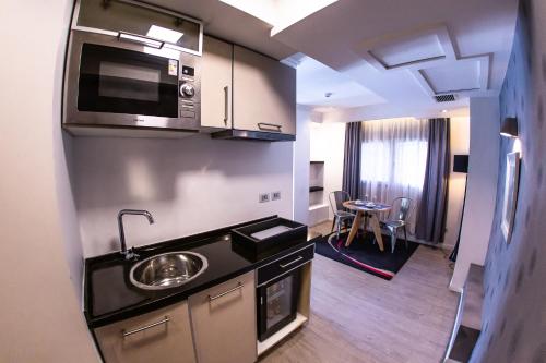 a small kitchen with a sink and a microwave at Hotel Sommelier Agustinas in Santiago