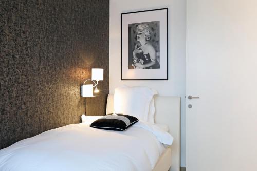 a bedroom with a bed with a black pillow on it at Luxury Suite Koksijde 301 Adult only in Koksijde