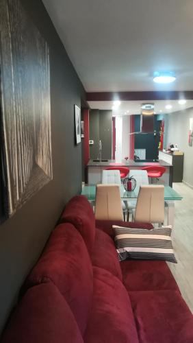 a living room with a red couch and chairs at El rincón de los Lanchares in Sotillo de la Adrada