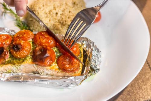 a person holding a fork and a plate of food at Ibis Porto Alegre Assis Brasil in Porto Alegre