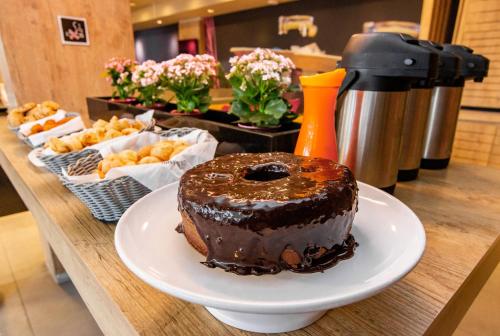 a chocolate cake on a plate on a table at Ibis Porto Alegre Assis Brasil in Porto Alegre