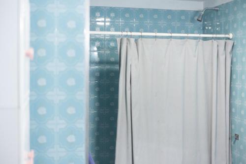 a bathroom with a shower with a white curtain at Hostel Cha in Resistencia