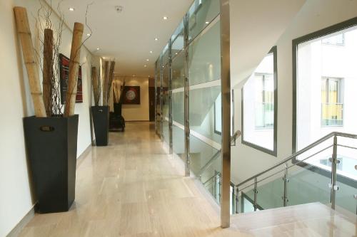 a hallway with glass walls and a stair case at Leflet Valme in Dos Hermanas