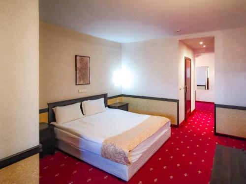 a hotel room with a bed and a red carpet at Trinity Residence Bansko in Bansko