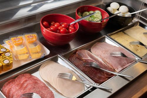 a tray of food with meat and tomatoes and other foods at ibis Sint Niklaas Centrum in Sint-Niklaas