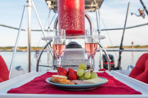a plate of fruit on a table with two glasses of wine at Romantic Escape in Downtown St Augustine in Saint Augustine