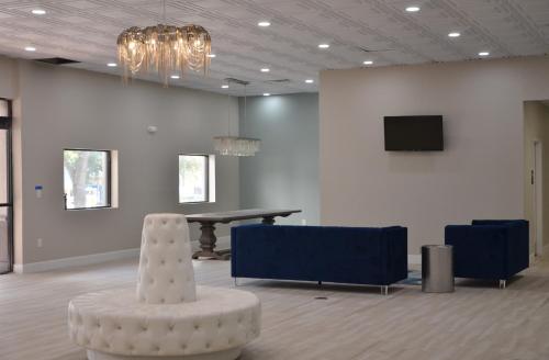 Habitación con mesa, silla y TV. en Opal Hotel & Suites en Orlando