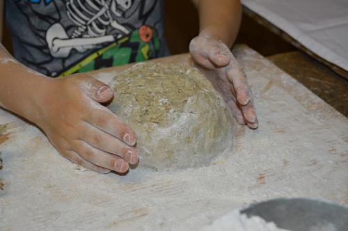 a person is making a ball of dough on a table at Lahnerhof in Campo Tures