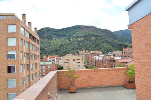 a view of a city with buildings and a mountain at Suites Casa 95 in Bogotá