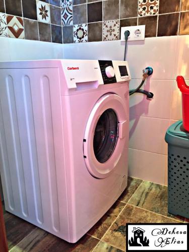 una lavadora rosa en una sala de lavandería en Dehesa Elías, en Lucena