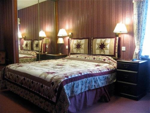 a bedroom with a large bed and two lamps at Gairloch Highland Lodge in Gairloch