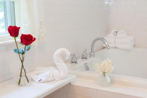 a bathroom with two roses and a swan on a sink at Adair Country Inn & Restaurant in Bethlehem