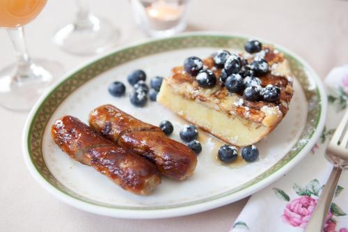 a plate of food with sausage and blueberries on a table at Adair Country Inn & Restaurant in Bethlehem