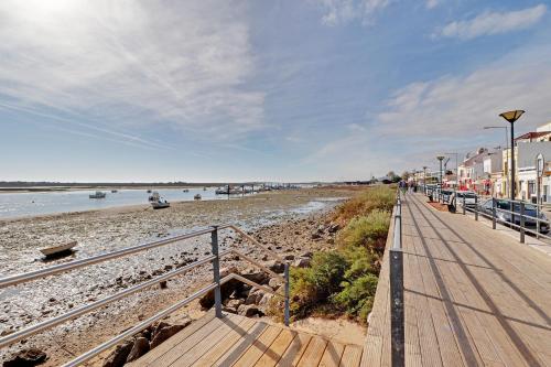 a boardwalk leading down to a beach with houses at Tavira Formosa Bay 1 by Homing in Cabanas de Tavira