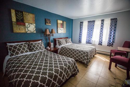 a bedroom with two beds and a chair in it at Squirrel Tree Resort in Leavenworth
