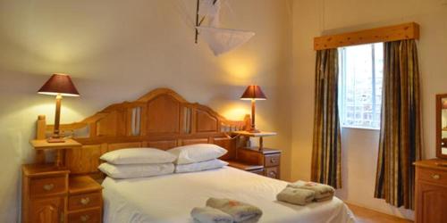 a bedroom with a large bed with white sheets and pillows at Seeheim Hotel in Seeheim