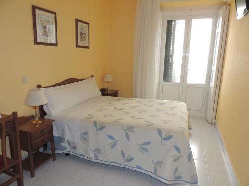 Schlafzimmer mit einem Bett und einem Fenster in der Unterkunft Hostal Gonzalo in Madrid