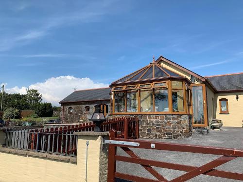 a building with a wooden fence in front of it at The Croft Guest House in Narberth