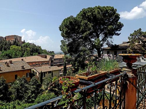 un balcone con diverse piante in vaso e una città di Casa Ariodante a Perugia