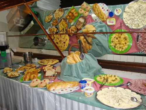 ein Tisch mit einer Reihe von verschiedenen Arten von Lebensmitteln in der Unterkunft Hotel Gaivota in Itacuruçá