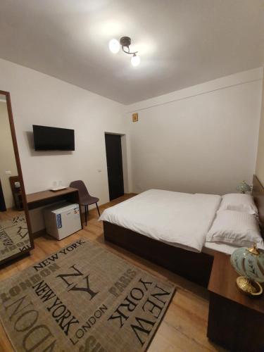 a bedroom with a bed and a television and a rug at Vily Luxury Rooms in Focşani