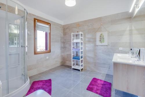 W łazience znajduje się umywalka i prysznic z fioletowymi matami. w obiekcie Casa Aloe w Aronie