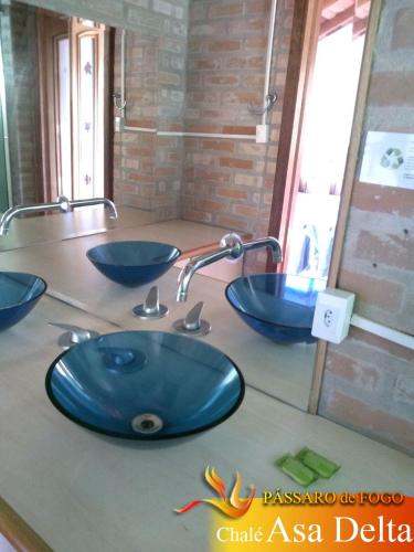 a bathroom with two blue sinks on a counter at Pássaro de Fogo in Santo Antônio do Pinhal