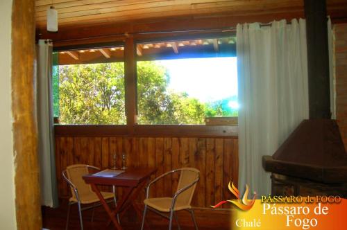 a room with a table and chairs and a window at Pássaro de Fogo in Santo Antônio do Pinhal
