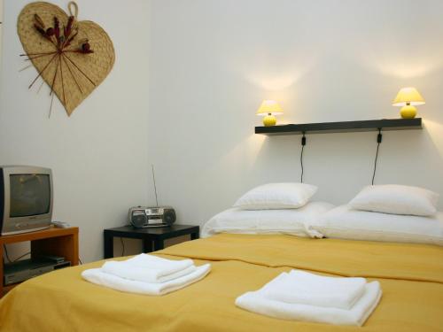 ブダペストにあるArriva Apartment, optional indoor parkingのテレビとタオルが備わるドミトリールームのベッド2台分です。