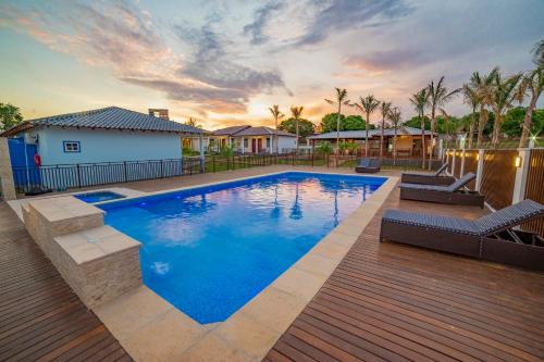 a swimming pool in a yard with a wooden deck at Pousada Ouro Preto de Bonito in Bonito