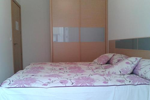 Una cama con un edredón rosa y blanco. en Apartamento Rural Arluzepe, en Echarri-Aranaz