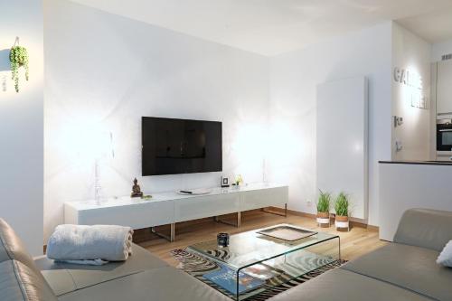 a living room with a tv on a white wall at Luxury Suite Koksijde 310 - Adults only in Koksijde