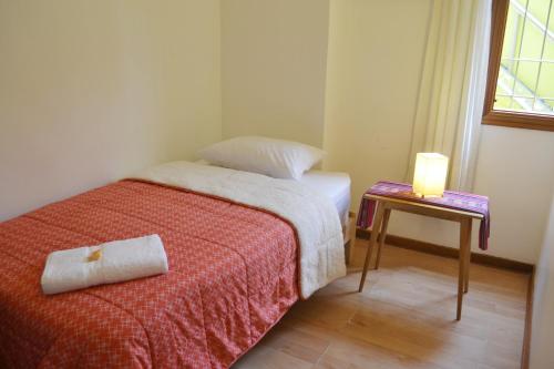 a small bedroom with a bed and a candle on a table at Casa Rodas in Lima