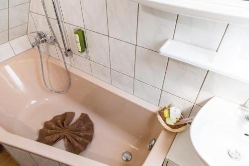 a bathroom with a tub and a toilet and a sink at Kräuterhotel Garni Zur Klostergrotte in Nohra