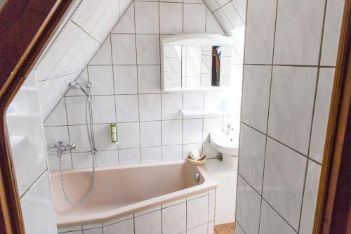 a bathroom with a bath tub and a sink at Kräuterhotel Garni Zur Klostergrotte in Nohra