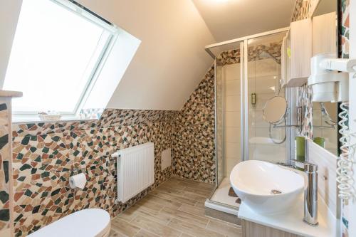 a bathroom with a sink and a toilet and a window at Kräuterhotel Garni Zur Klostergrotte in Nohra