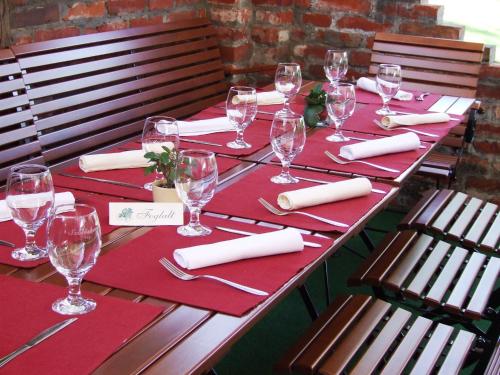 a long table with red napkins and wine glasses at Hotel Vineyard Inn - Szőlőskert in Nagykanizsa