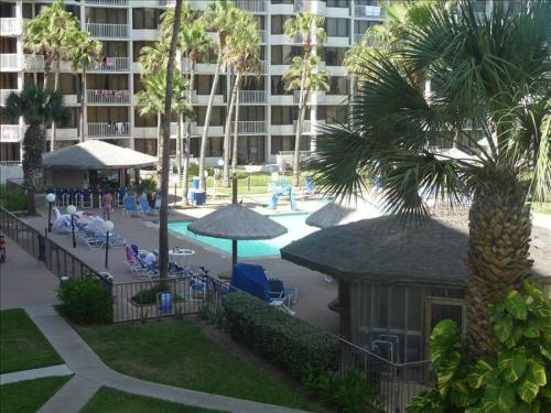 a resort with a pool and palm trees and a building at Saida IV Condos S4308 in South Padre Island