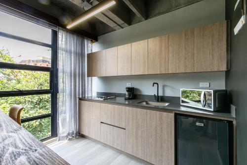 a kitchen with a sink and a microwave at Factory Lofts Hotel in Medellín