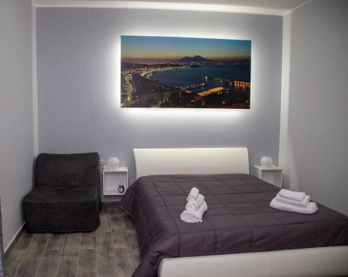 ein Schlafzimmer mit einem Bett und einem Stuhl in der Unterkunft Casa Marmolo - Cuore di Napoli in Neapel