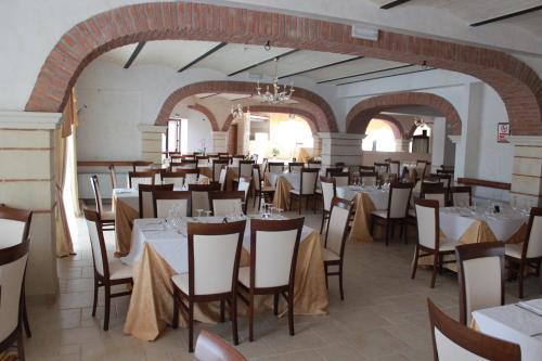 un restaurante con mesas y sillas en una habitación en Agriturismo Al Passaggio di Pirro, en Miglionico