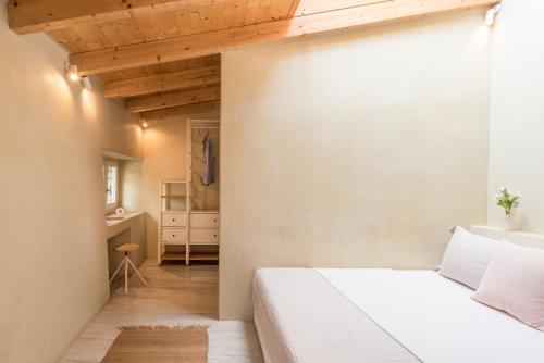 a bedroom with a white bed and a bathroom at Anafiotika hideaway acropolis Athens by Cycladica in Athens