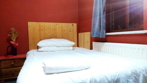 a bedroom with a bed with white sheets and pillows at Oldbrook Accommodation in Milton Keynes